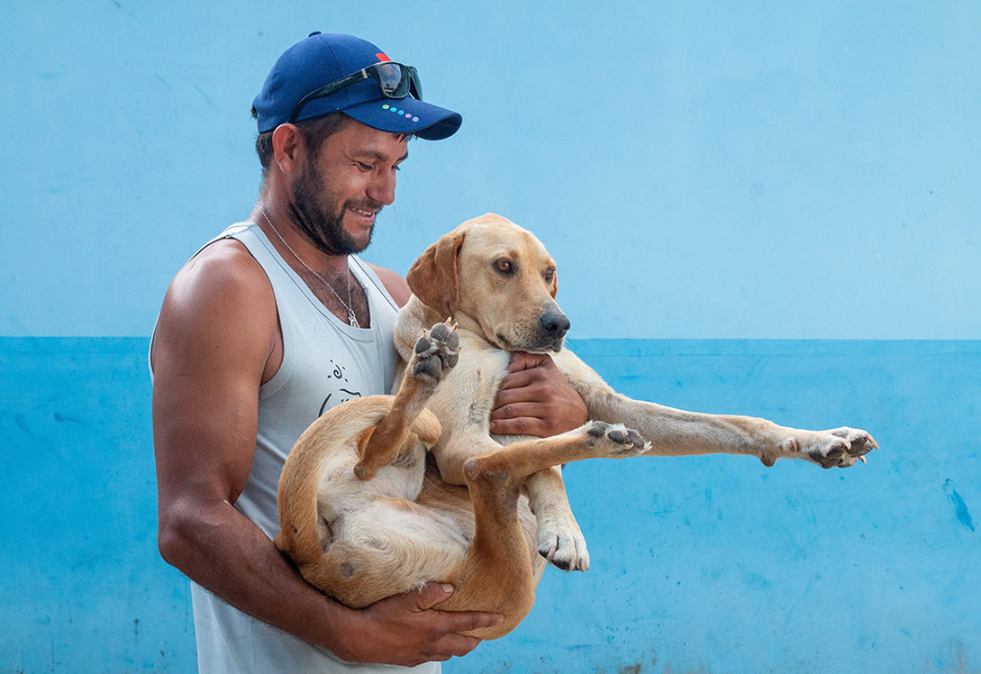 Morador levando seu cão para ser vacinado na Ação Clínica da Barra do Superagui, PR, em 2019. Créditos: Oruê Brasileiro 